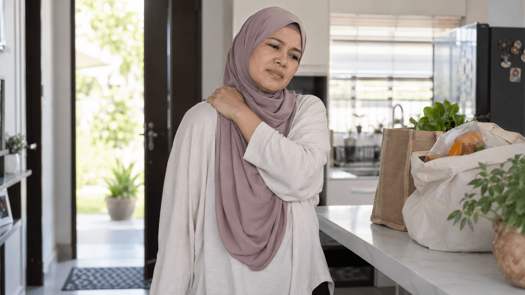 Wanita memegang bahu selepas melakukan aktiviti harian